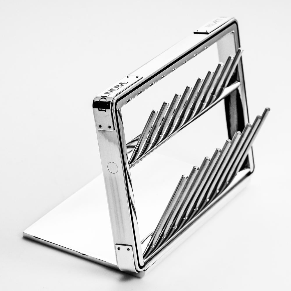 A polished metal display frame on a flat base, holding two rows of angled rods